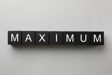 Image of Word Maximum made of black cubes on white background, top view