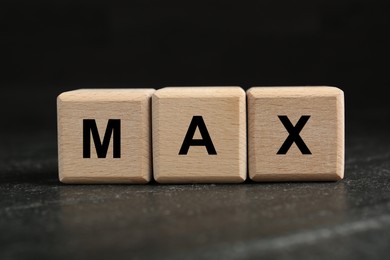 Image of Word Max made of wooden cubes on black table