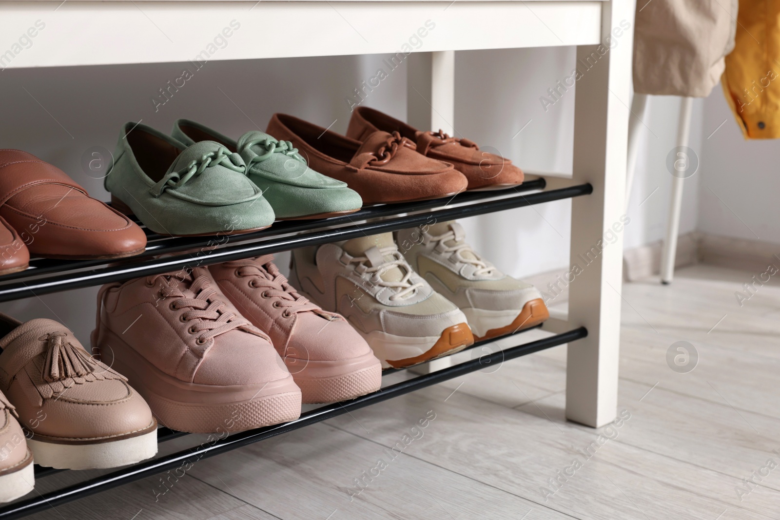 Stand with different stylish shoes indoors, closeup Photo of Stand with different stylish shoes indoors, closeup