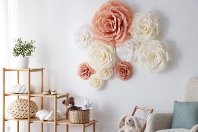 Photo of Beautiful decorative paper flowers on white wall in child's room