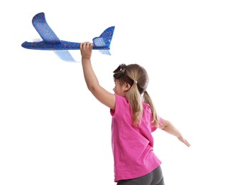 Photo of Cute little girl playing with toy plane on white background