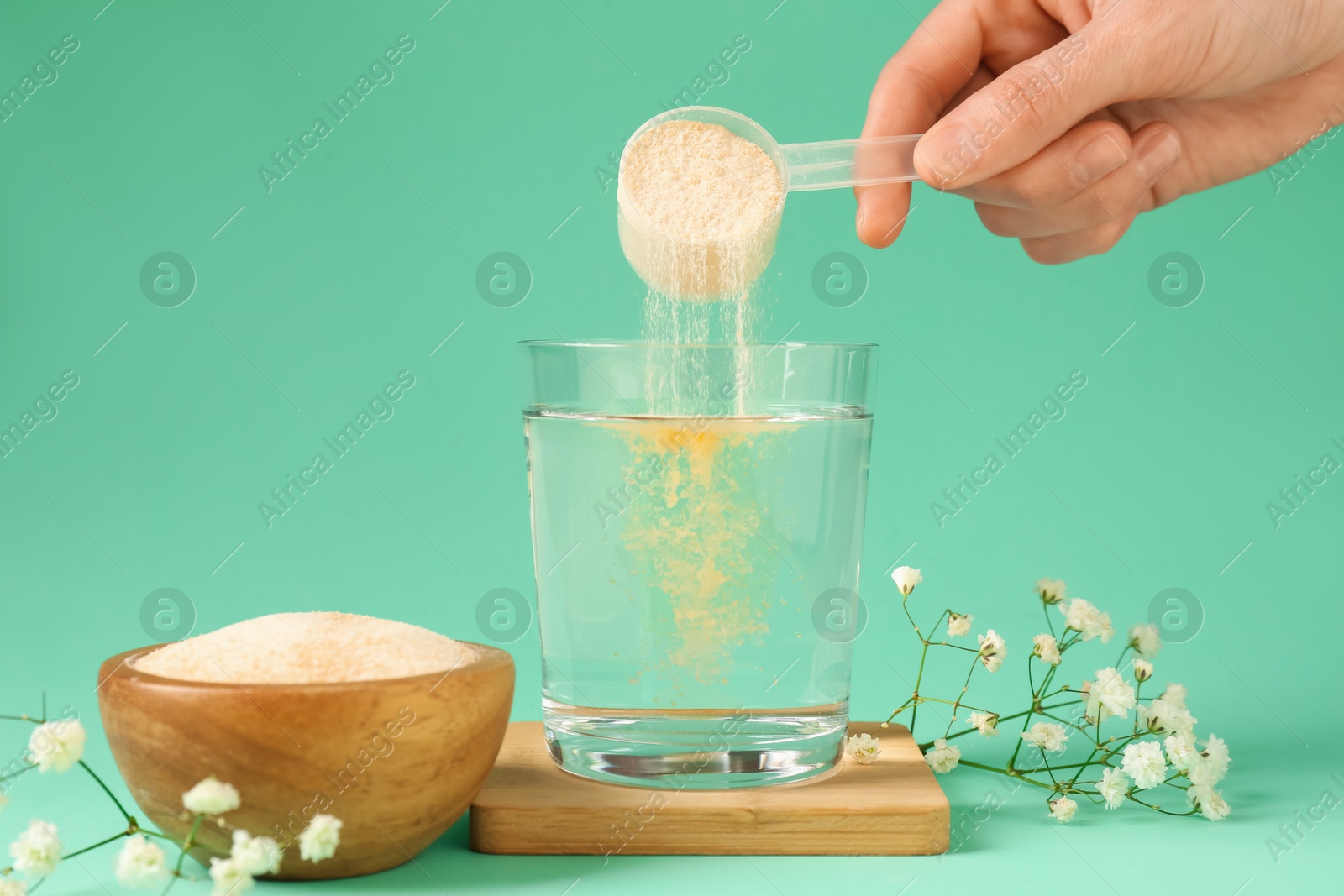 Woman adding collagen powder into glass with water on turquoise background, closeup Photo of Woman adding collagen powder into glass with water on turquoise background, closeup
