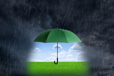 Image of Open umbrella revealing green meadow under blue sky during heavy rainstorm