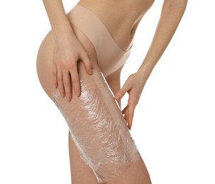 Photo of Woman doing spa body wraps on her leg against white background, closeup