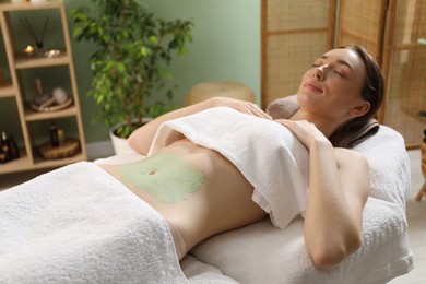 Photo of Woman undergoing body wraps treatment in spa salon