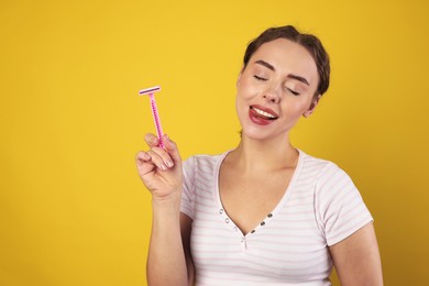 Photo of Happy woman with razor on light green background, space for text. Hair removal tool