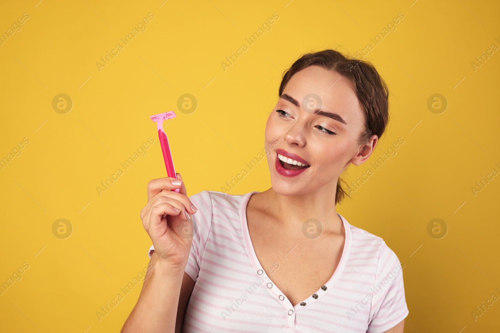 Photo of Happy woman with razor on light green background. Hair removal tool