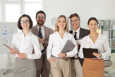 Photo of Portrait of happy coworkers in formal clothes indoors