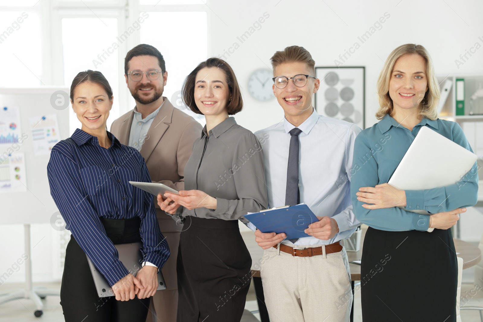 Photo of Portrait of happy coworkers in formal clothes indoors