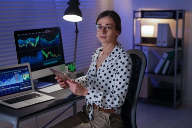 Photo of Stock exchange. Woman working in office at night