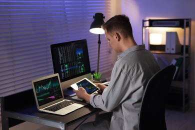 Photo of Stock exchange. Man working in office at night