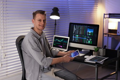 Photo of Stock exchange. Man working in office at night