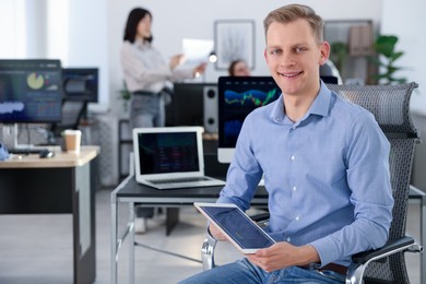 Photo of Stock exchange. Man working at desk in office