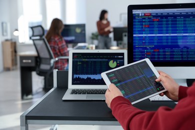 Photo of Stock exchange. Man working at desk in office, closeup