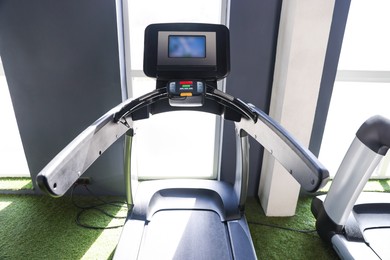 Photo of One treadmill with display in gym. Sports equipment