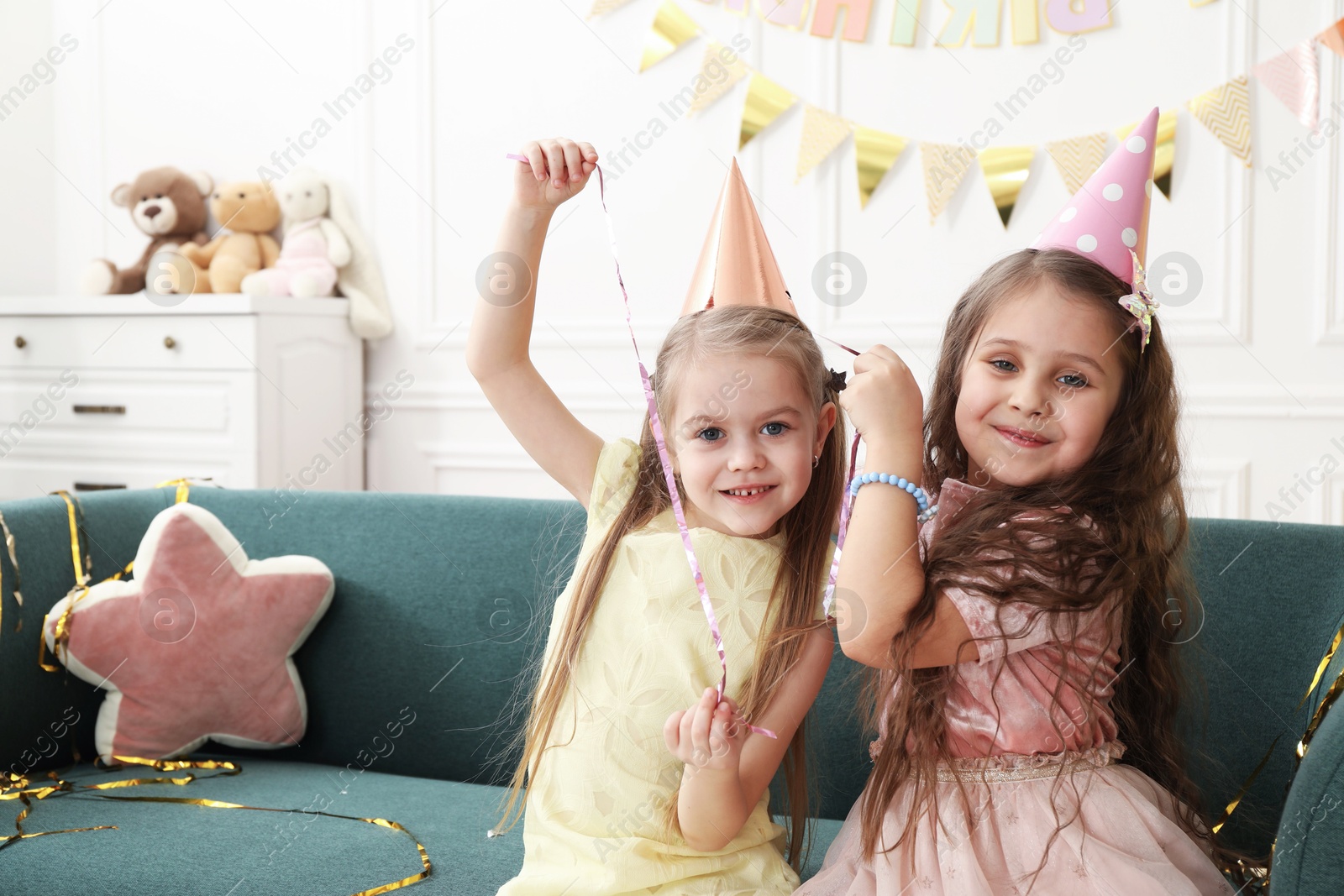 Photo of Children in conical paper hats indoors. Surprise party