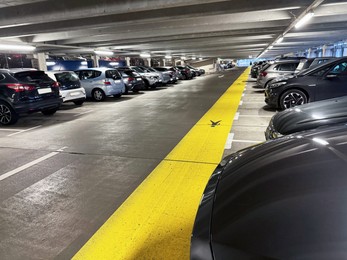 Photo of Many parked cars in underground garage of apartment complex