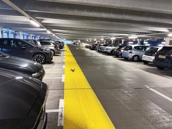 Photo of Many parked cars in underground garage of apartment complex