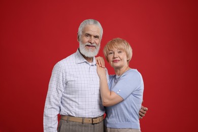 Photo of Portrait of lovely senior couple on red background