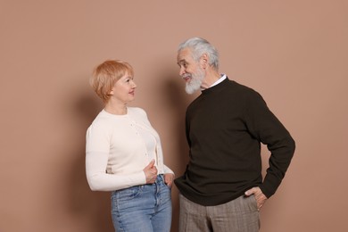 Photo of Happy senior couple looking at each other on beige background