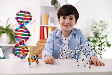 Photo of Boy with DNA structure model at desk indoors