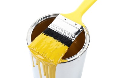 Photo of Can of yellow paint and brush isolated on white