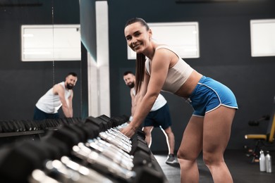 Photo of Athletic woman training with dumbbells in gym