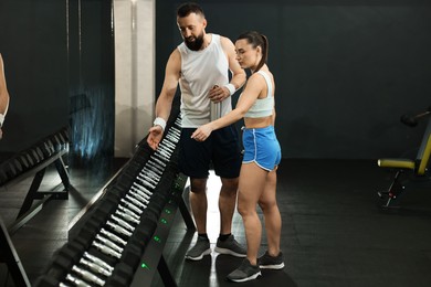 Photo of Athletic couple training with dumbbells in gym