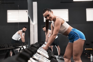 Photo of Athletic woman training with dumbbells in gym