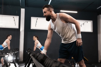 Photo of Athletic man training with dumbbells in gym