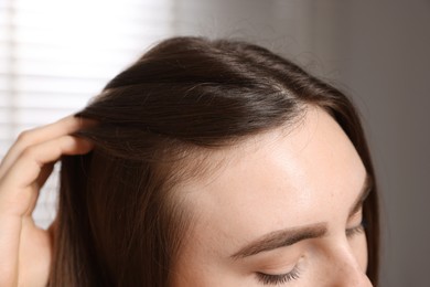 Photo of Woman with healthy hair roots on blurred background, closeup