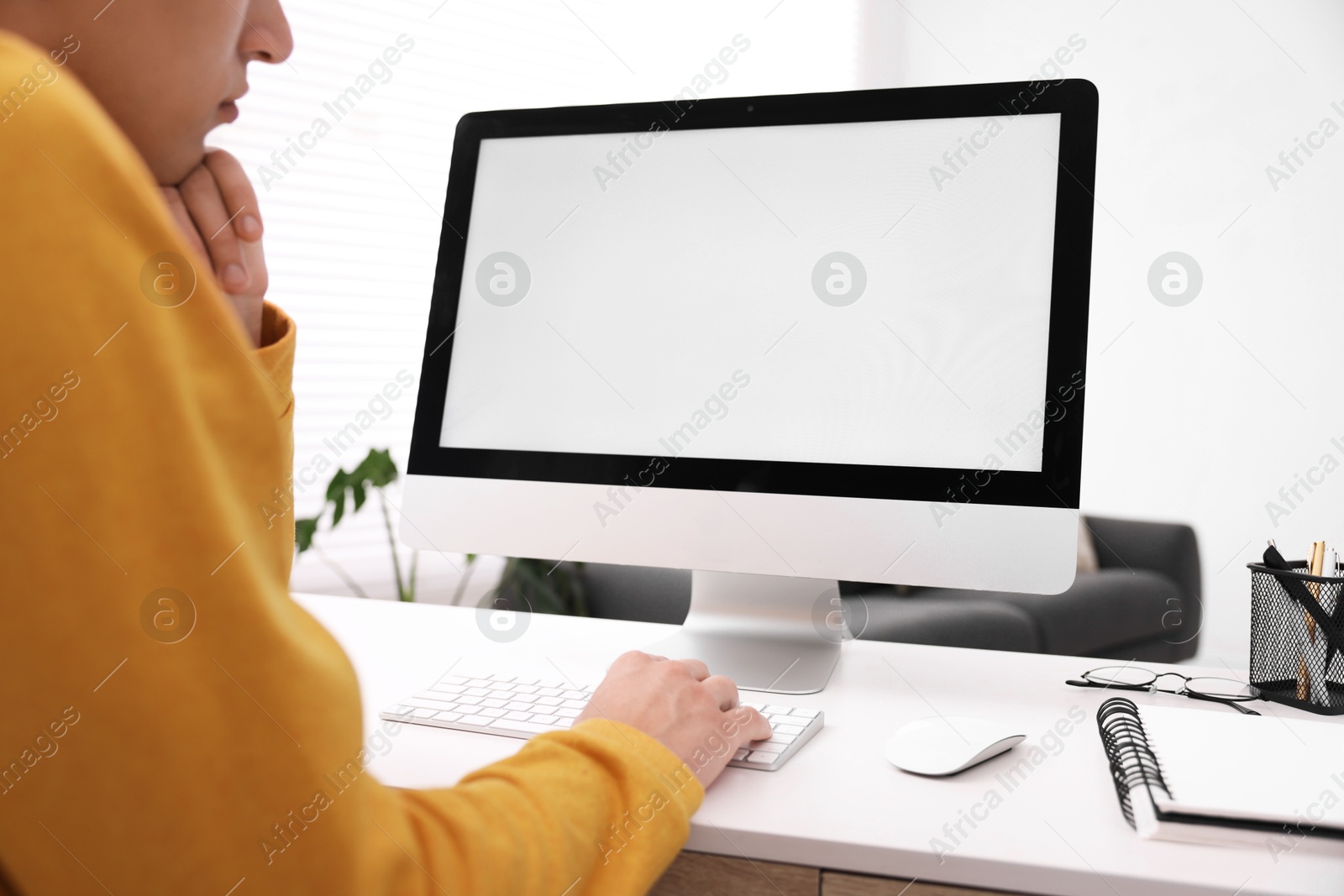 Photo of Man working on computer at white desk in office, closeup. Mockup for design