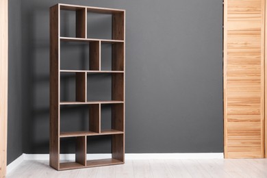 Photo of Empty shelving unit and folding screen near grey wall indoors, space for text