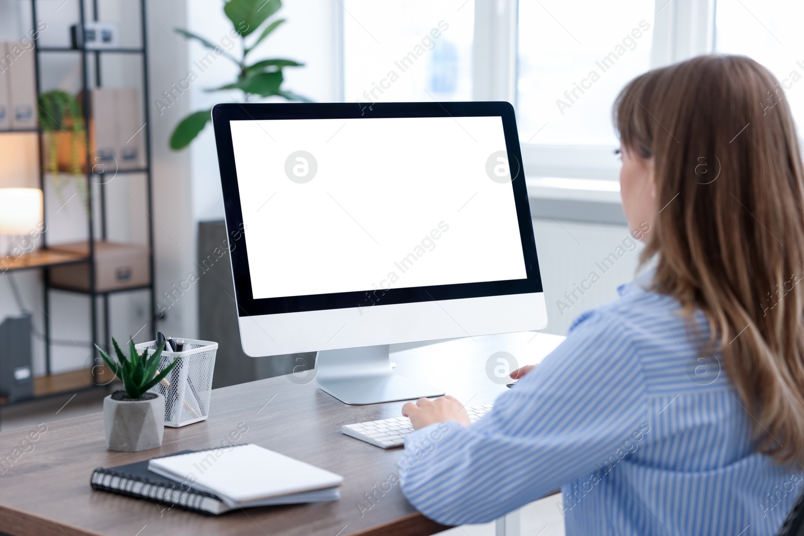 Photo of Woman working on computer at wooden desk in office. Mockup for design