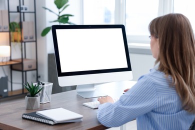 Photo of Woman working on computer at wooden desk in office. Mockup for design