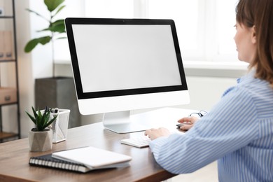 Photo of Woman working on computer at wooden desk in office. Mockup for design