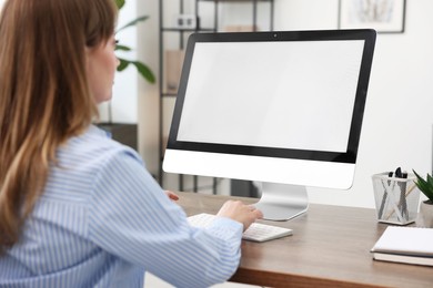 Photo of Woman working on computer at wooden desk in office. Mockup for design