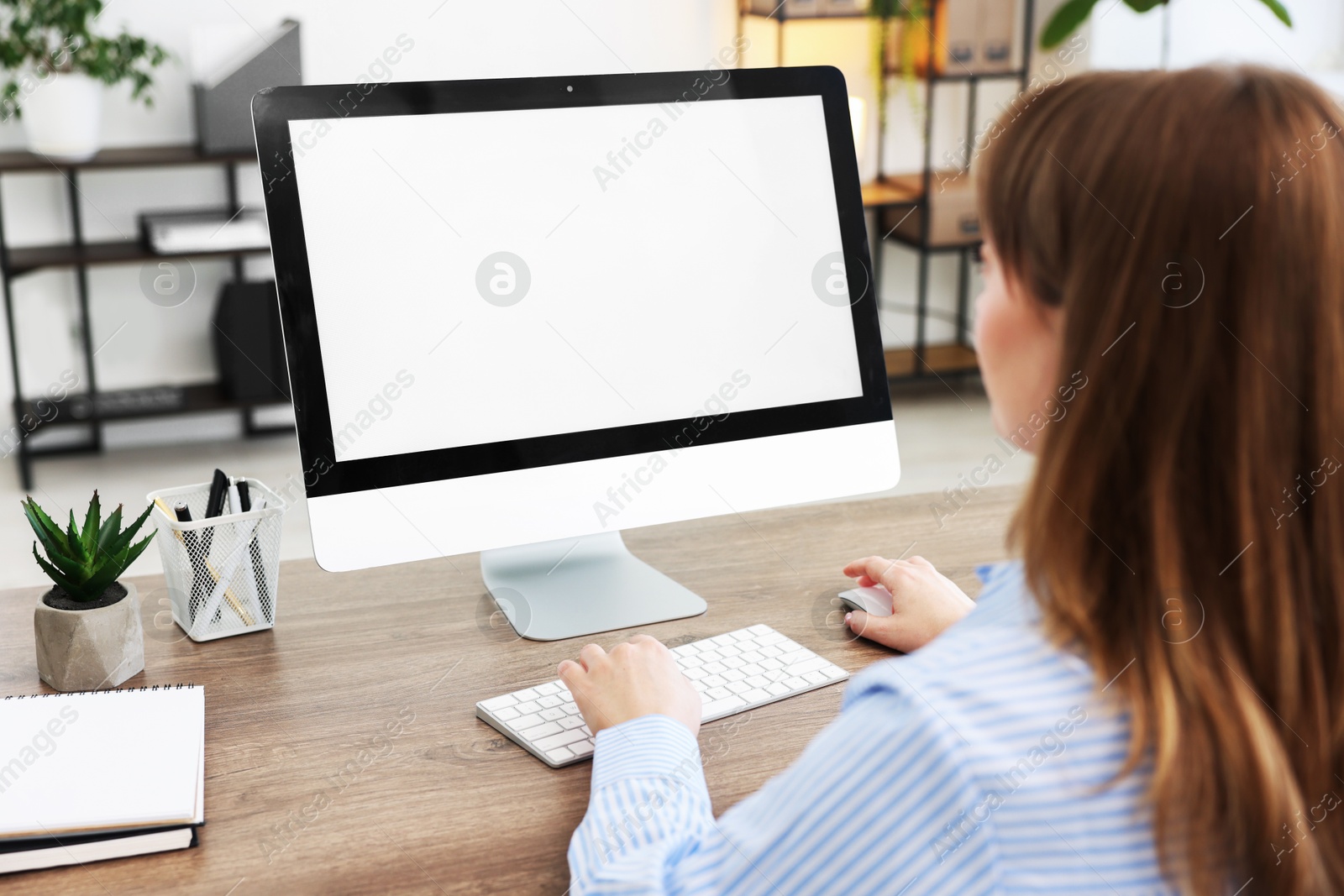 Photo of Woman working on computer at wooden desk in office. Mockup for design