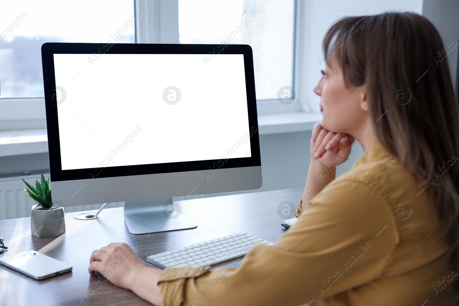 Photo of Woman working on computer at wooden desk in office. Mockup for design