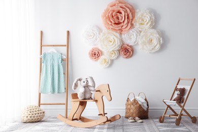 Photo of Beautiful decorative paper flowers on white wall in child's room