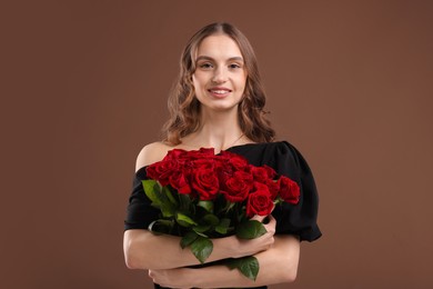 Photo of Smiling woman with bouquet of roses on brown background