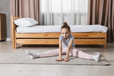 Photo of Little girl exercising at home. Morning routine