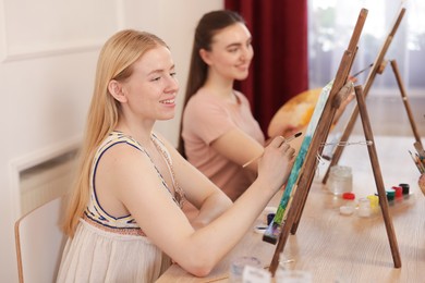 Photo of Smiling women learning to draw at table in class