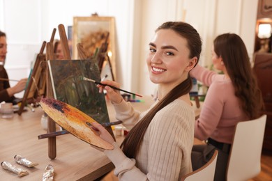 Photo of Group of women learning to draw at wooden table in class