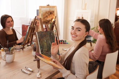 Photo of Group of women learning to draw at wooden table in class