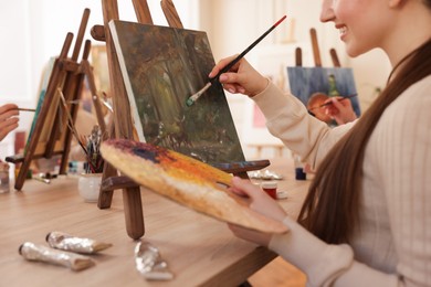 Photo of Women learning to draw at wooden table in class, closeup