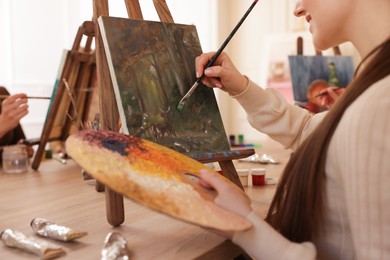 Photo of Women learning to draw at wooden table in class, closeup