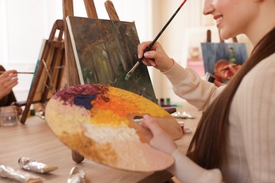 Photo of Women learning to draw at wooden table in class, closeup