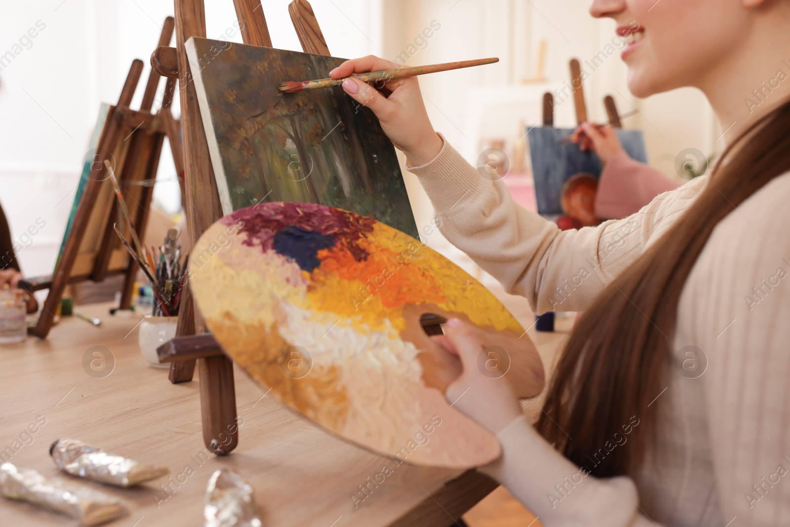 Photo of Women learning to draw at wooden table in class, closeup