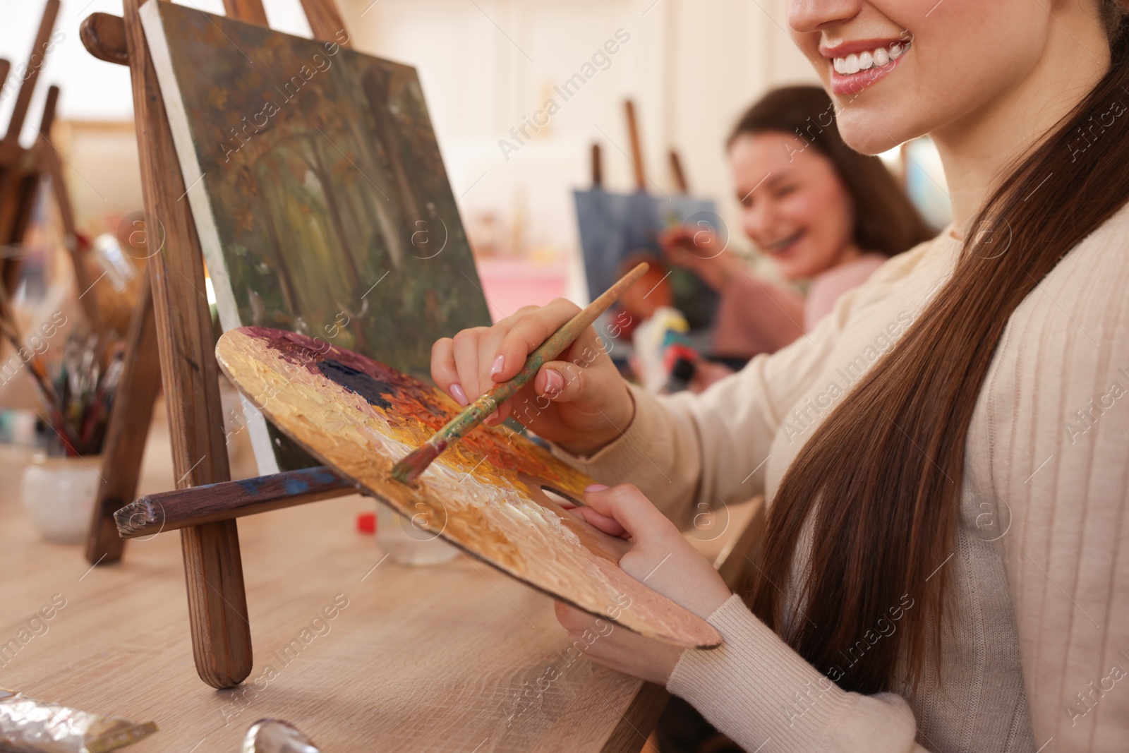 Photo of Women learning to draw at wooden table in class, closeup